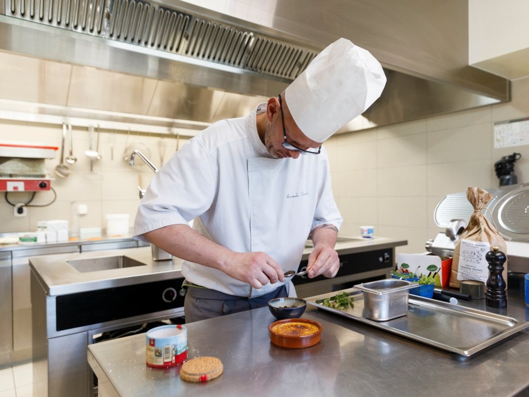 Le chef de cuisine, Alexandre Chausson fait la mise en plat de sa "crème brûlée au chèvre, lentilles confites et pickles de cerises” à l’Auberge le Relais à Chavannes-de-Bogis