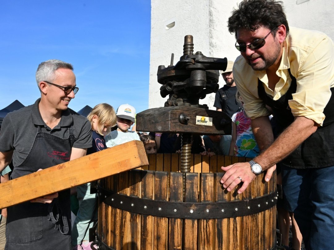 Denis Hermanjat, de Founex, et Jean-Daniel Heiniger, d'Eysins, s'occupent du pressage du raisin lors de la Fête de la vigne à Nyon.